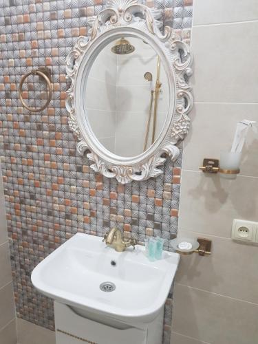 a bathroom with a sink and a mirror on the wall at Borjomi Classic Hotel in Borjomi
