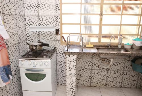 a kitchen with a stove and a sink at Recanto Novo Piumhi in Piumhi