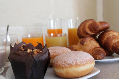 een tafel met donuts en gebak en glazen sinaasappelsap bij Coluni Sport & Resort srl in Gravina in Puglia