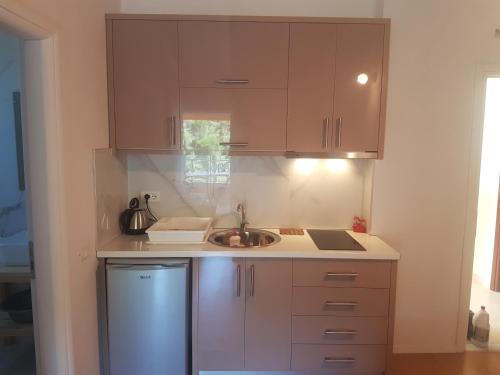 a kitchen with brown cabinets and a sink at Villa Xani in Himare