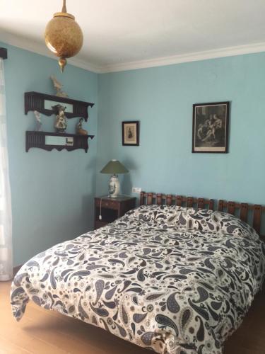 a bedroom with a bed with a black and white comforter at Casa Rural Antigua Ermita del Rosario in Teba