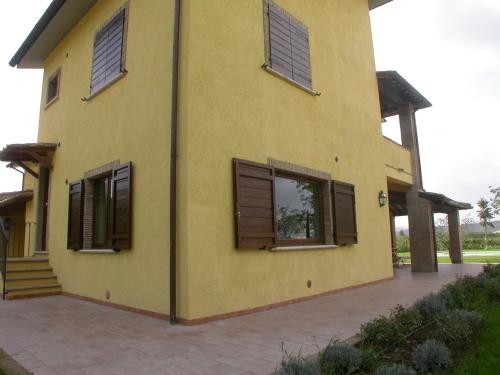 a yellow house with brown shuttered windows at Casavacanze Sant'Eugenia in Attigliano