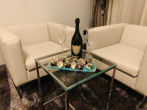 a table with a bottle of wine and a plate of cupcakes at Merit Grand Mosta Spa Hotel & Casino in Svilengrad
