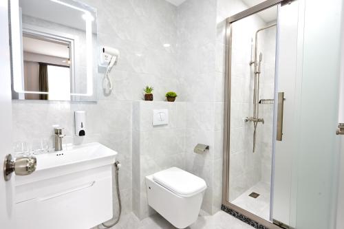 a bathroom with a shower and a toilet and a sink at Graphica Tbilisi Hotel in Tbilisi City