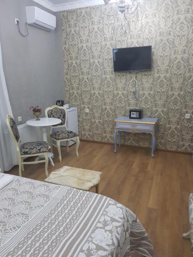 a room with two beds and a tv on the wall at Borjomi Classic Hotel in Borjomi