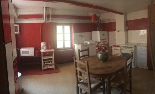 uma cozinha com uma mesa de madeira e uma cozinha com paredes vermelhas em Twin cosy au coeur de Sanary em Sanary-sur-Mer