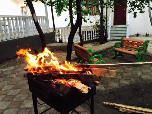 een vuur in een grill naast twee banken bij вилла in Tbilisi City