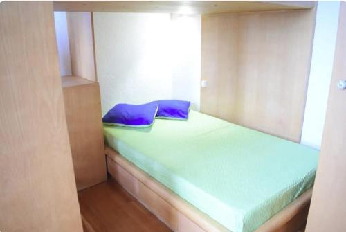 a small bed with blue pillows in a room at Un Balcon Sur La Mer in Funchal