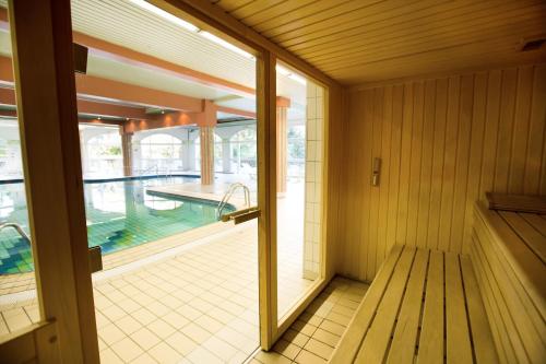 a room with a balcony with a swimming pool at Hotel *** & Spa Vacances Bleues Villa Marlioz in Aix-les-Bains