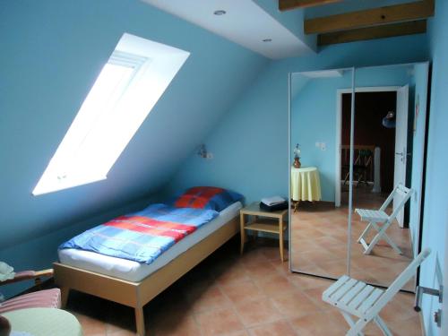 ein blaues Zimmer mit einem Bett und einem Fenster in der Unterkunft Haus Siegfried in Niebüll