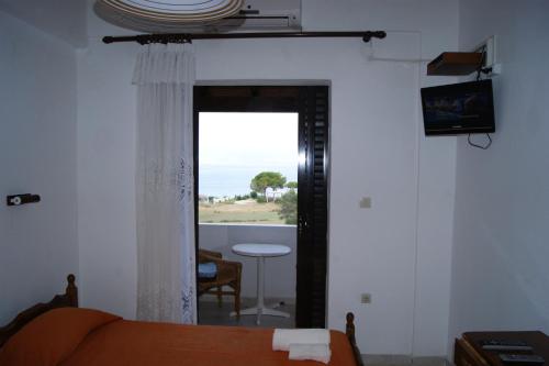 Habitación con cama, ventana y mesa. en VillaBouka2, en Astrakeri