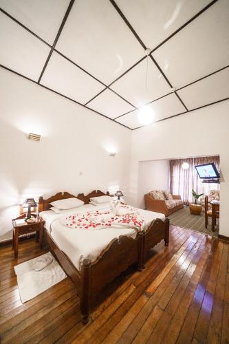 a bedroom with a bed with roses on it at Hotel Glendower in Nuwara Eliya