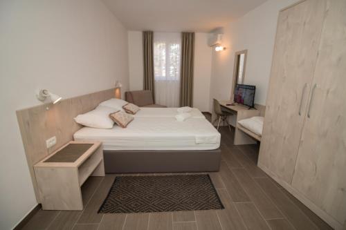 a small bedroom with a bed and a desk at Ninas Apartments in Mostar