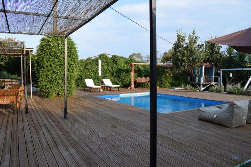 a backyard with a swimming pool and a wooden deck at Serenity Luxury Villa, Skiathos in Agia Paraskevi