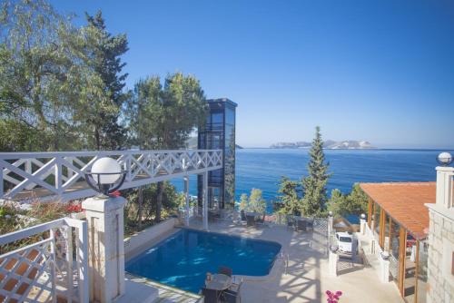 a house with a swimming pool and the ocean at Medusa Hotel in Kaş