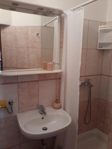 a bathroom with a sink and a mirror and a shower at Apartment Božava - Nena in Božava