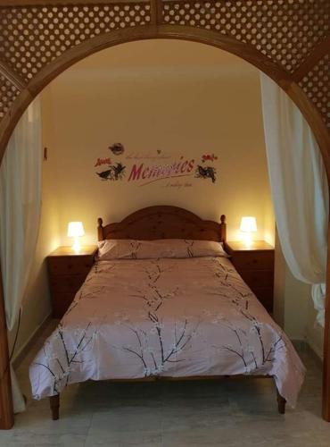 a bedroom with a bed with a wooden head board at Beachfront Bungalow in Torrox Costa