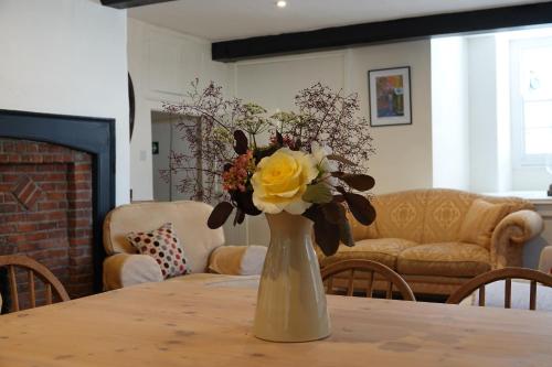 a vase filled with yellow and white flowers on a table at The Yard House in Sherborne