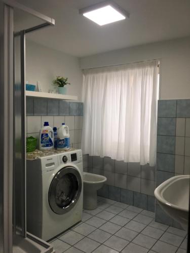 a bathroom with a washing machine and a toilet at AFFITTACAMERE LA TRAVERSA in San Cataldo