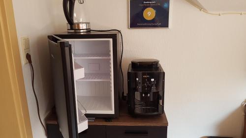 a coffee maker sitting on a table next to a refrigerator at Ferienwohnung Zauberhaft in Bad Soden-Salmünster