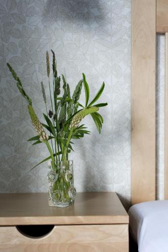 a glass vase with flowers on a table at Hotel Kallgården in Järpen