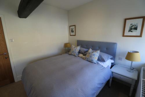 Un dormitorio con una cama grande y una mesa con una lámpara. en The Yard House, en Sherborne