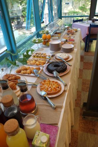 a long table with a buffet of food on it at Hotel Ivano in Rimini
