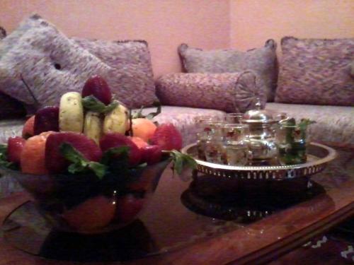 un bol de fruta en una mesa en la sala de estar en Hôtel Tijani, en Fez