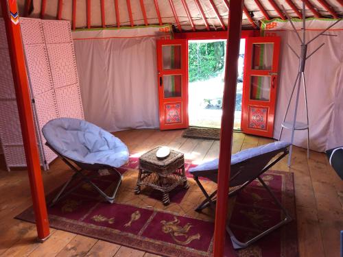 a room with a chair and a table in a tent at Yourte Mongole in Mont-Roc