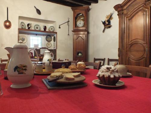 una mesa con un mantel rojo con comida. en Anousta, en Loubajac