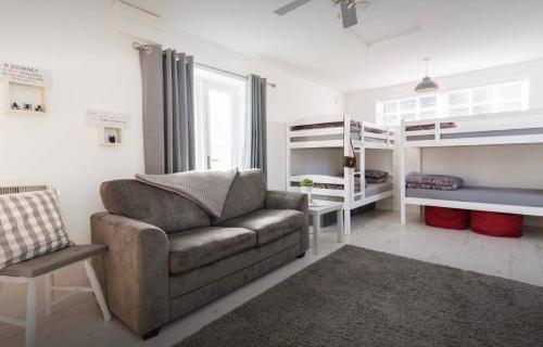 een woonkamer met een bank en een stapelbed bij The Shed in Merthyr Tydfil