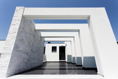 a corridor of a white building with a door at Crystal villas & suites in Polykhrono