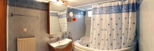uma casa de banho com uma cortina de chuveiro e um lavatório em Thesshouse Pefka FK em Tessalônica