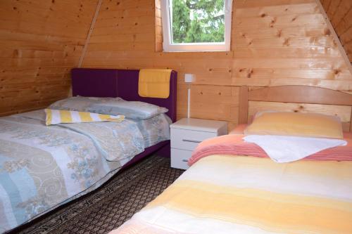 a bedroom with two beds in a log cabin at Apartment Andjela in Žabljak