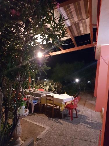 a patio with a table and chairs at night at Villa DonnAnna in Cariati