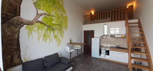 ein Wohnzimmer mit einem Sofa und einem Baumbild an der Wand in der Unterkunft Apartmány Vila Singles in Leitmeritz