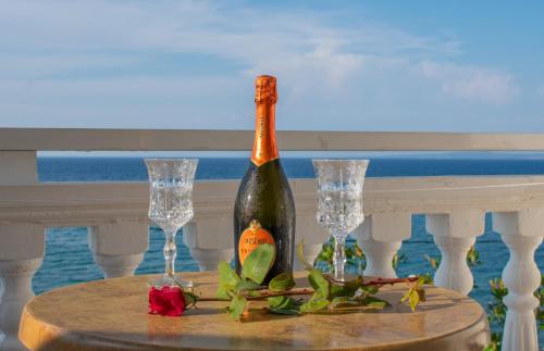 Agoulos Beach Hotel في أرغاسي: زجاجة من النبيذ على طاولة مع كأسين