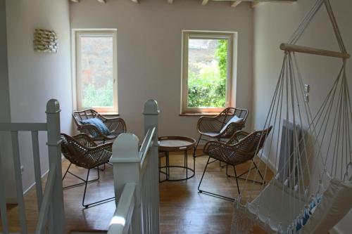 une chambre avec des chaises, une table et des fenêtres dans l'établissement La Folie des Remparts, à Carcassonne