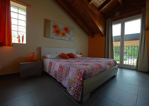 a bedroom with a bed in a room with windows at I Fiori di Malpensa in Ferno