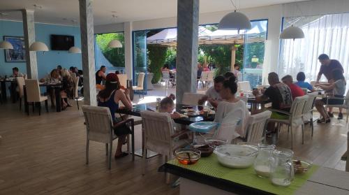 een groep mensen die aan tafels in een restaurant zitten bij Hotel Shipka Beach in Sunny Beach