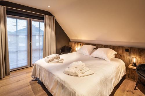 1 dormitorio con 1 cama grande y toallas. en BARNEYS HOUSE en Sint-Laureins
