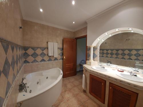 uma casa de banho com uma banheira e um lavatório e uma banheira em Hotel Arco del Sol em Colmenar