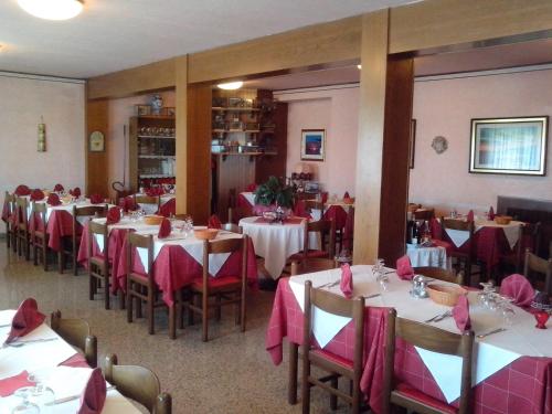 un comedor con mesas y sillas con servilletas rosas en Hotel Monte Fior, en Foza