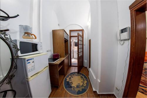 einen Flur mit einem TV und einem Kühlschrank in einem Zimmer in der Unterkunft Ada Old Town Apartments 3 in Braşov