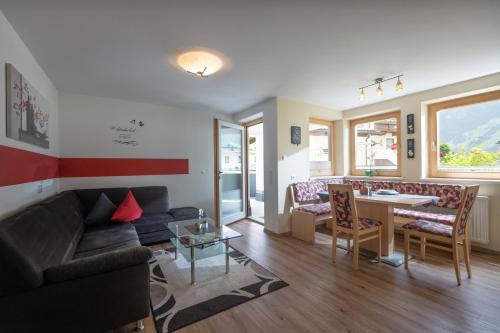 a living room with a couch and a table at Ferienwohnung Taschler in Ramsau im Zillertal