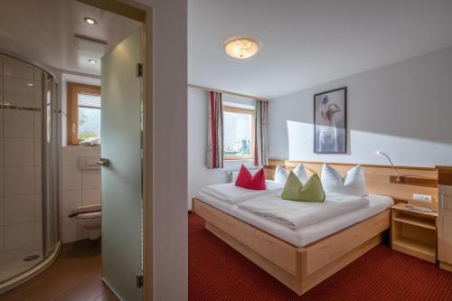 Habitación de hotel con cama con almohadas rojas y verdes en Ferienwohnung Taschler, en Ramsau im Zillertal