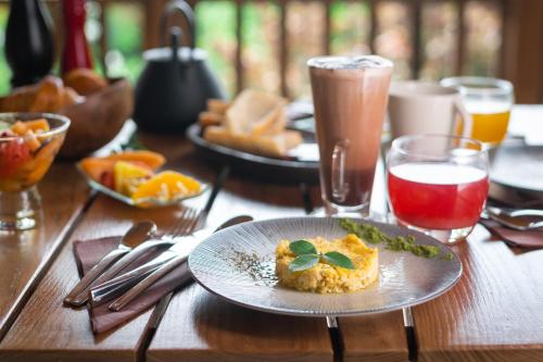 a wooden table with a plate of food and drinks at French Coco in La Trinité