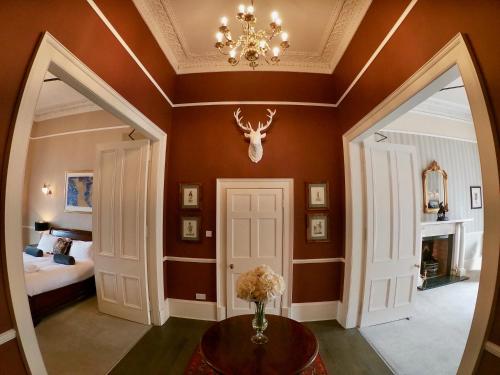 a room with a bed and a vase of flowers on a table at Escape To Edinburgh @ Albyn Place in Edinburgh