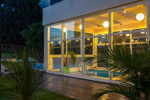 a house with large glass windows and a patio at Valeria Playa Apart in Valeria del Mar