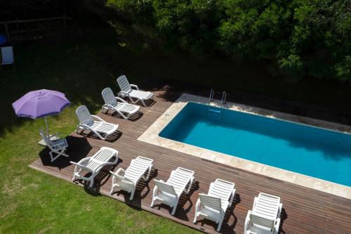 a group of chairs and an umbrella next to a swimming pool at Valeria Playa Apart in Valeria del Mar